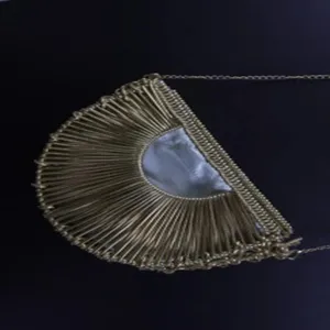 Handmade metallic crescent handbag detail, stylish half-round metal shoulder bag with chain.