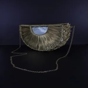 Close-up detail of the stylish half-moon woven crossbody bag with metallic chain strap.