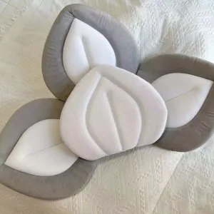 Primo piano del cuscino da bagno per neonati grigio e bianco con centro in rete traspirante.