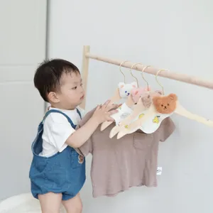 INS style wooden baby clothes hanger with cute plush bear head design for nursery storage.