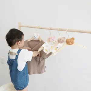 Wooden children clothes hangers with cute plush bear heads, perfect for kids room storage.