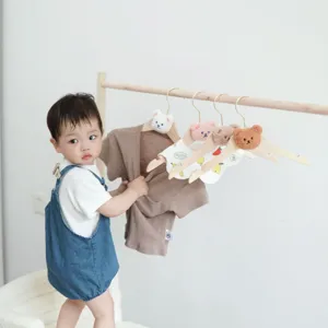 Wooden baby clothes hanger with cute plush bear head design, aesthetic kids nursery organizer.