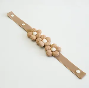 Gros plan détaillé de l'attrape-rideau fleuri kaki de style coréen minimaliste en tissu doux.