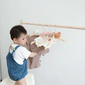 Wooden baby clothes hangers with cute plush bear heads for nursery organization and kids room.