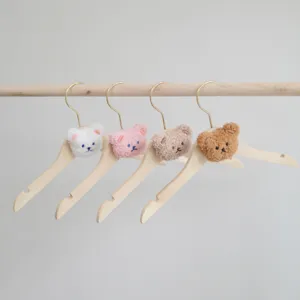 Wooden kids clothes hangers featuring cute embroidered plush bear heads in assorted colors.