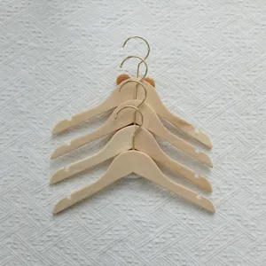 Wooden children clothes hangers with cute bear ears and gold hooks set for nursery decor.