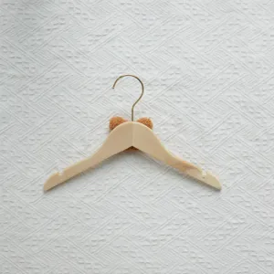 Wooden children clothes hanger with cute brown plush bear head detail, ideal nursery storage.