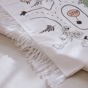 Close-up detail of soft Nordic children play mat with fringe and cute road map pattern.