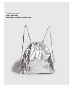 Nahaufnahme Detail des glänzenden metallisch silbernen Kordelzug Rucksacks mit Gurten.