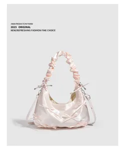 Dettaglio borsa in raso rosa, manico arricciato, fiocchi carini e fibbia metallica.