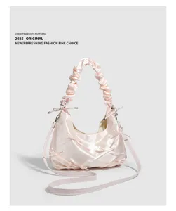 Dettaglio borsa a spalla in raso rosa con fiocchi carini, manico arricciato e morbida.
