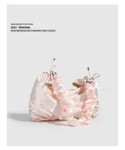 Dettaglio borsa a mano raso rosa arricciato, fiocchi decorativi, stile elegante spalla.