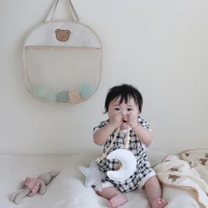 Detailed view of cute bear hanging mesh storage bag in baby room, ideal for bathroom and toys.