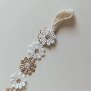 Daisy embroidery strap detail, cute floral baby pacifier holder accessory close up view
