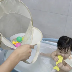 Detailed view of mesh bath toy storage bag hanging in bathroom with colorful toys inside.