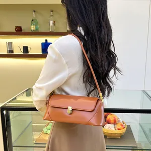 Stylish brown leather baguette shoulder bag with metallic lock for women daily wear.