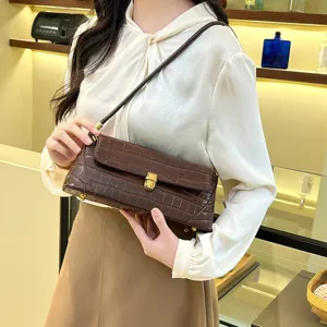 Chic brown crocodile pattern baguette shoulder bag, detailed clasp and stylish underarm design.