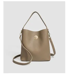 Λεπτομερής όψη casual τσάντας bucket σε taupe χρώμα με μεταλλικό κούμπωμα και λουράκι.