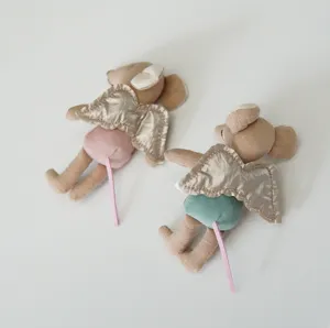 Cute mini plush mouse toy with golden angel wings and colorful shorts, lovely detail view.
