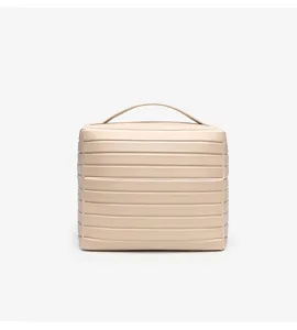 Detail shot of minimalist beige striped cosmetic storage bag with top handle and PU leather.