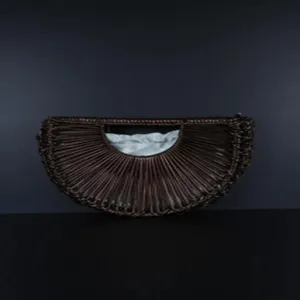Hand-woven semi-circular rattan crescent handbag detail showing natural texture and light lining.