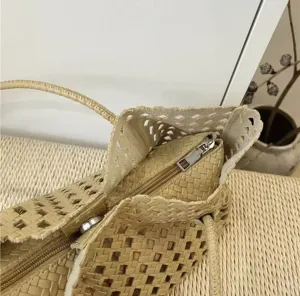 Woven leather shoulder bag detail with hollow-out mesh design and zipper closure.