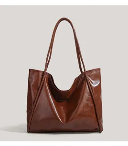 Brown glossy polyurethane tote bag detail, featuring long shoulder straps design.