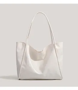 White patent leather tote bag detail, minimalist shoulder bag texture and fine strap design.