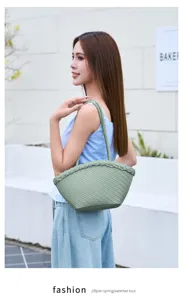 Detailed shot of the stylish woven shell shoulder tote bag in light green, perfect resort style.