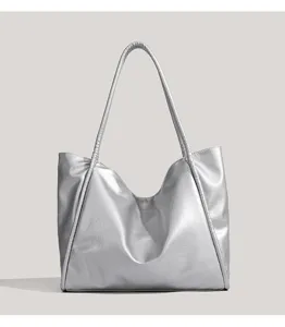 Silver tote bag detail showing metallic texture, spacious design, and sturdy shoulder straps.