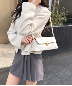 Close-up detail of white leather baguette shoulder bag worn by model, simple daily casual style.