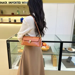 Detailed view of stylish brown leather baguette shoulder bag with metal lock in nice scene.