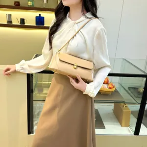 Beige fashion baguette shoulder bag, minimalist underarm style with elegant metal lock.