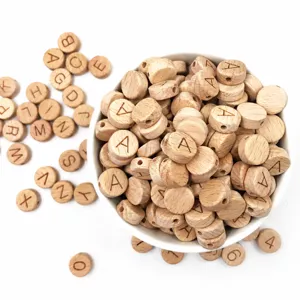 Detail de perles en bois avec lettres alphabet gravees sur des disques en hetre naturel.