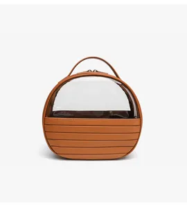 Clear cosmetic bag detail view, transparent makeup organizer with brown handle and textured base.