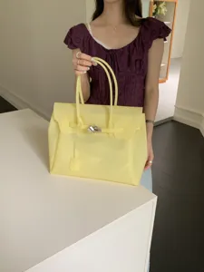 Stylish yellow PVC jelly tote bag for women, large capacity shoulder handbag with chic lock design.