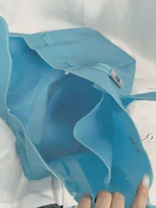 Blue PVC jelly tote bag detail showcasing spacious interior and structured handles.