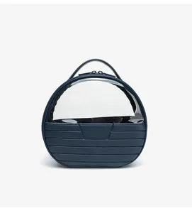 Close-up detail of navy blue round cosmetic bag with clear window and stylish ribbed base design.
