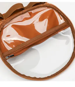 Clear cosmetic bag detail shot, transparent PVC storage pouch with brown zipper trim.