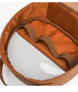 Detail view of brown cosmetic travel bag interior with transparent compartment and elastic bands.