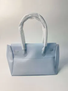 Sac cabas fourre-tout en PVC bleu clair avec doubles poignées et fermoirs métalliques femme.