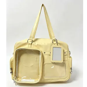 Yellow Ita bag detail view showing clear display window and heart zipper pulls for merch.