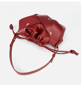 Detail shot of the burgundy leather pleated shoulder bag, featuring elegant drawstring closure.