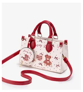 Detail view of the cute bear print handbag, featuring red handles and a matching coin purse.