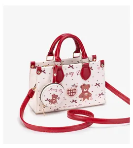 Close-up detail of the cute cartoon bear print handbag with red handles and small coin pouch.