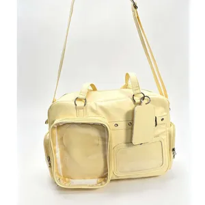 Yellow ita bag detail showing clear front window, double handles, and adjustable shoulder strap.
