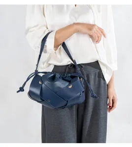 Dark blue woven leather shoulder bag with drawstring closure and chic metal bee charms stylish.