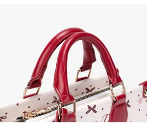 Close-up detail shot of a cute handbag featuring red leather handles and patterned body.