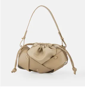 Beige leather pleated shoulder bag detail, stylish drawstring closure, elegant metal knot.