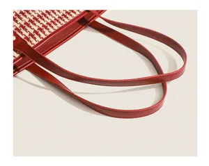 Detailed view of the red leather shoulder straps and houndstooth tweed texture on women tote bag.